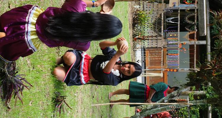 Inheemse vrouwen in traditionele klederdracht die een culturele demonstratie opvoeren op een dorpsplein