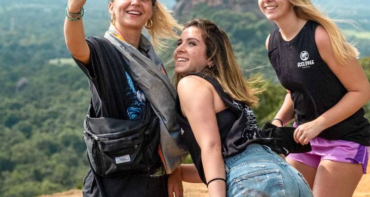 Trois femmes prenant un selfie avec de la verdure en arrière-plan.