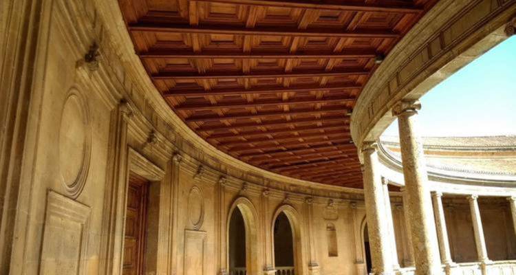 Interior de edificio con arcos y techo de madera.