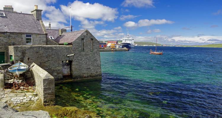 Port avec des bâtiments en pierre et une eau bleue claire.