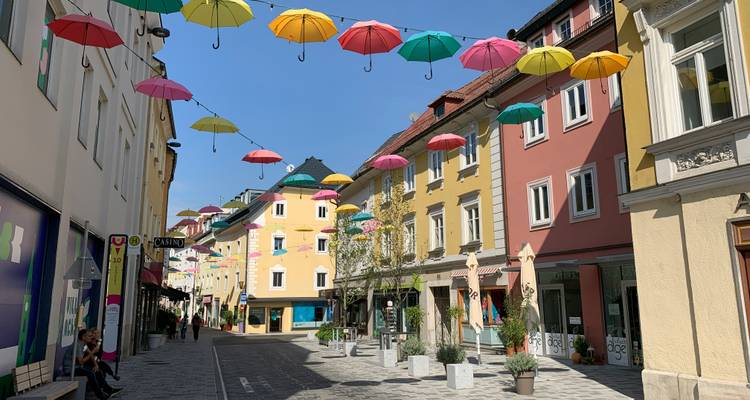 Straße mit bunten Schirmen, die über Kopf hängen.