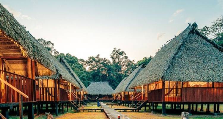 Traditionele hutten in een dorpse omgeving onder een blauwe hemel.