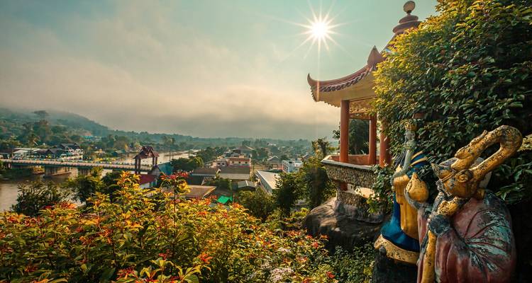 Scenic pagoda with lush greenery and a river view.