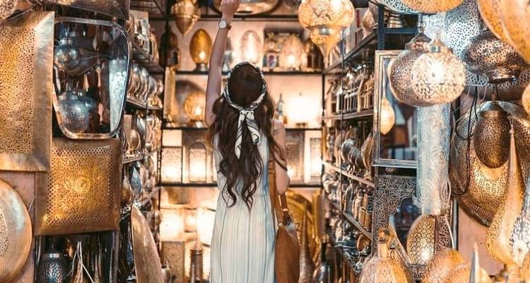 Eine Person in einem lebendigen Laternenladen, die nach einem Licht greift.