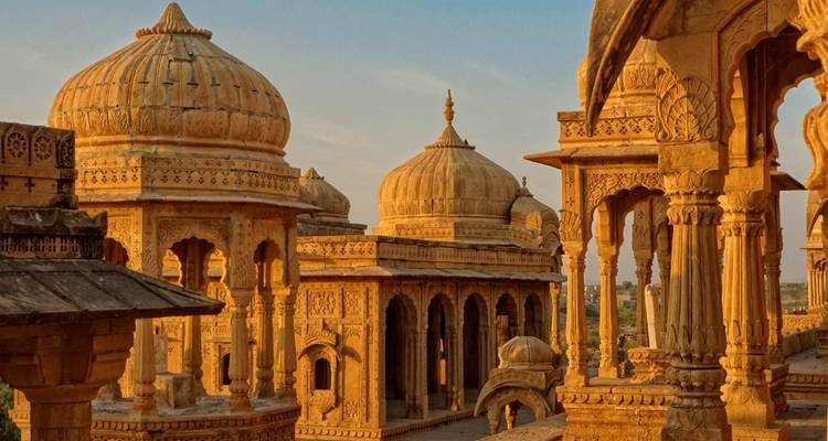 Structures à dômes ornés brillant dans la lumière du coucher de soleil.