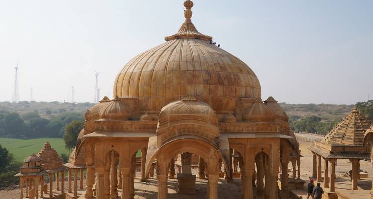 Chhatri en pierre sur une colline contre un ciel légèrement nuageux.
