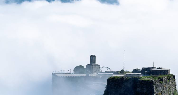 Une forteresse émergeant d'épais nuages.