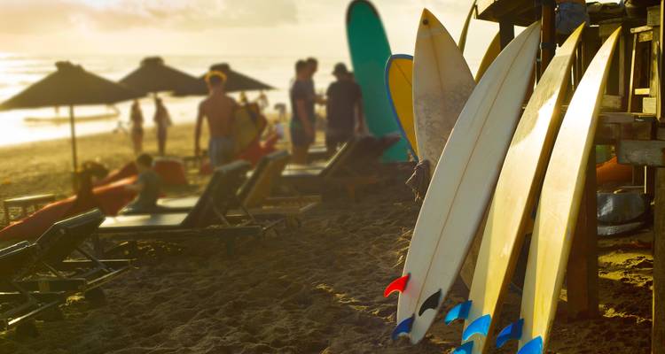 Surfbretter und Strandbesucher genießen einen Sonnenuntergang am Strand.