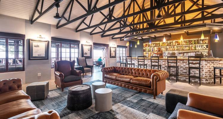 Innenraum einer Lounge mit Sitzbereich und Barbereich.