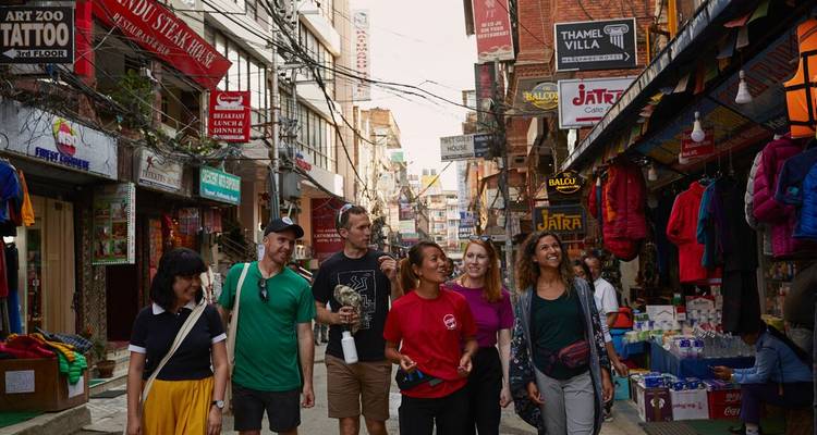 Groupe de personnes marchant à travers un marché de rue animé.