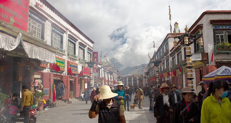 Des gens marchant dans une rue animée de la ville avec une architecture traditionnelle.