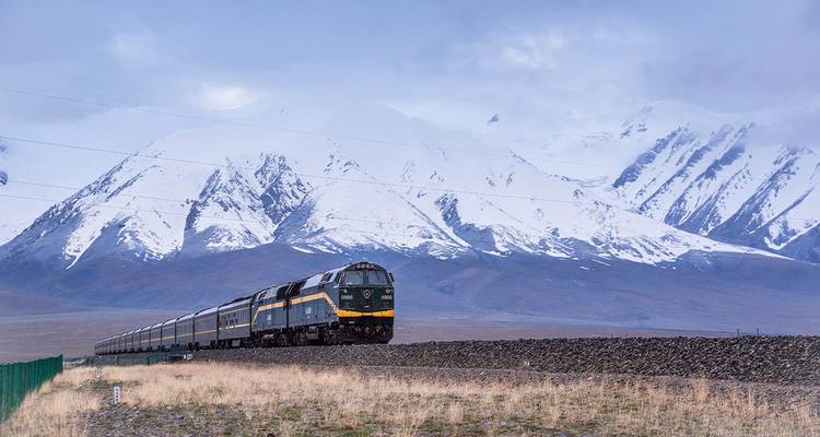 Train voyageant à travers un paysage montagneux enneigé.