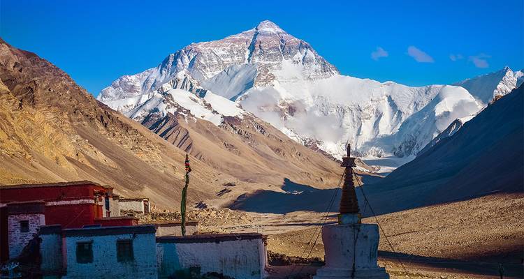 Majestueuse montagne avec un sommet enneigé sous un ciel bleu dégagé.
