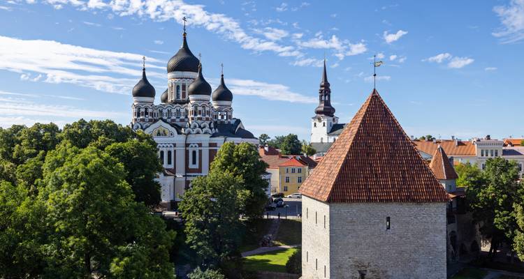 Skyline de Tallinn présentant les dômes de la cathédrale Nevski et une tour médiévale sur fond de ciel bleu.