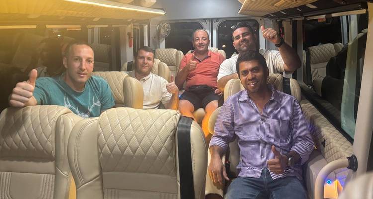 Un groupe d'hommes faisant un pouce levé à l'intérieur d'un véhicule.