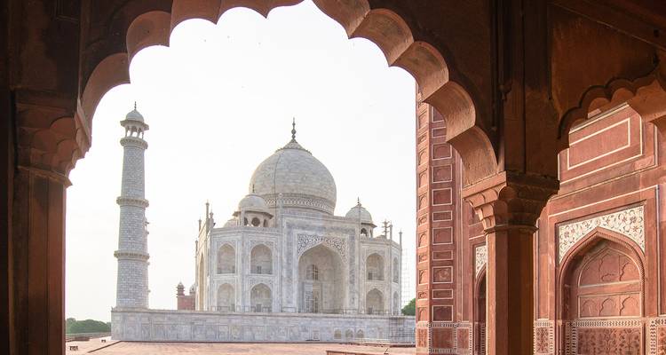 Iconic view of the Taj Mahal from an arched hallway.
