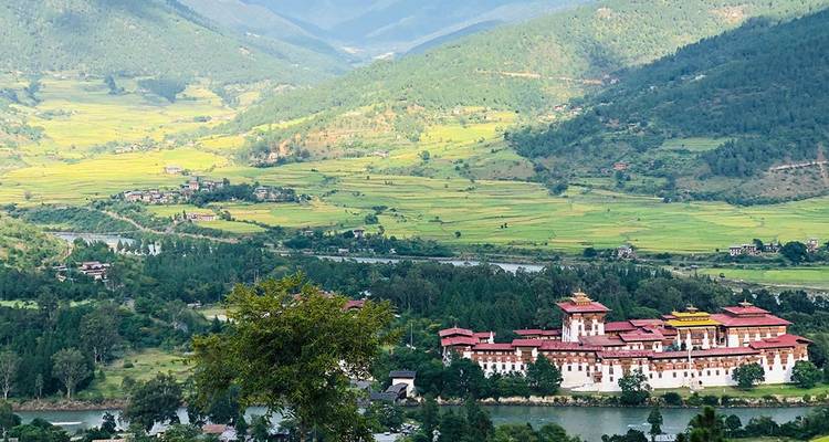 Vue panoramique d'une vallée avec un monastère historique et une rivière au Bhoutan.