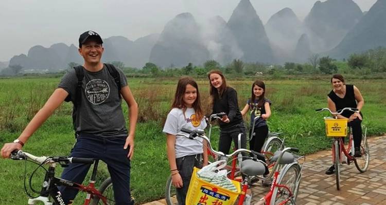 Grupo de personas en bicicleta por un sendero with montañas kársticas al fondo