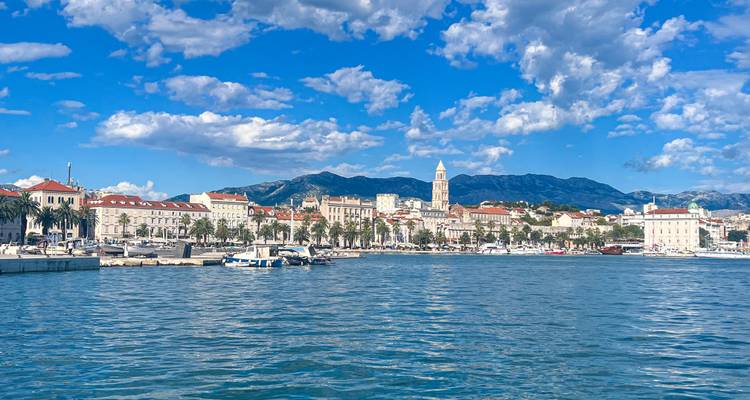 Coastal town with mountains and boats in the harbor.