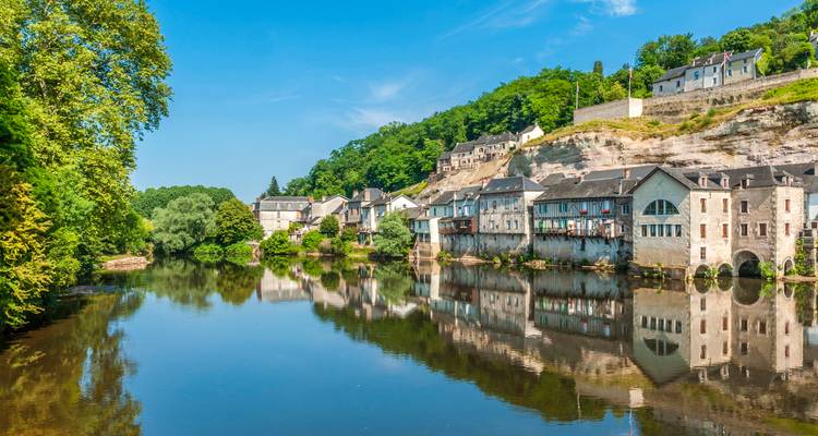 Charmante ville riveraine avec des bâtiments historiques et une végétation luxuriante.