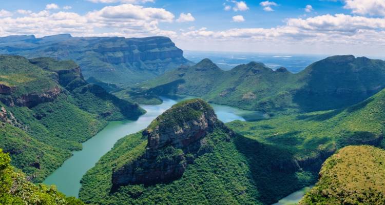 Eine dramatische Luftaufnahme des Blyde River Canyon mit smaragdgrünen Flüssen, die sich durch türmende grüne Klippen winden.