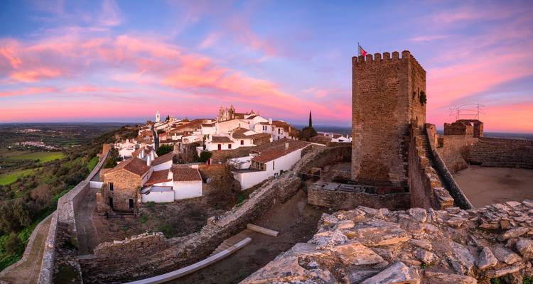 Vue aérienne d'un village fortifié au coucher du soleil.