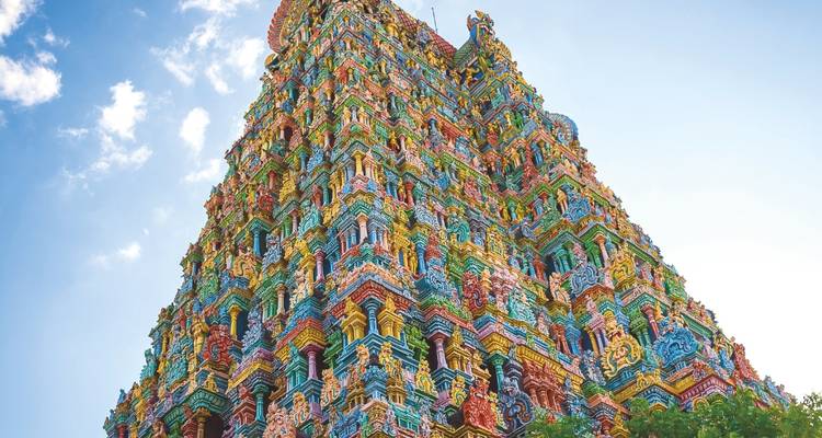 Un gopuram imposant aux couleurs éclatantes d'un temple du sud de l'Inde s'élève majestueusement dans un ciel dégagé.