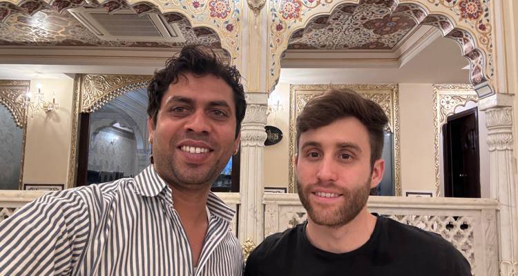Deux personnes souriantes à l'intérieur avec des arches ornées.