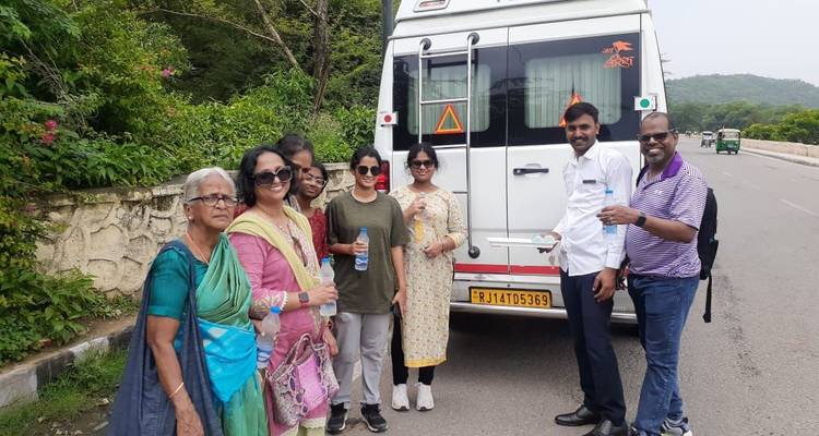 Tour group standing in front of a vehicle.
