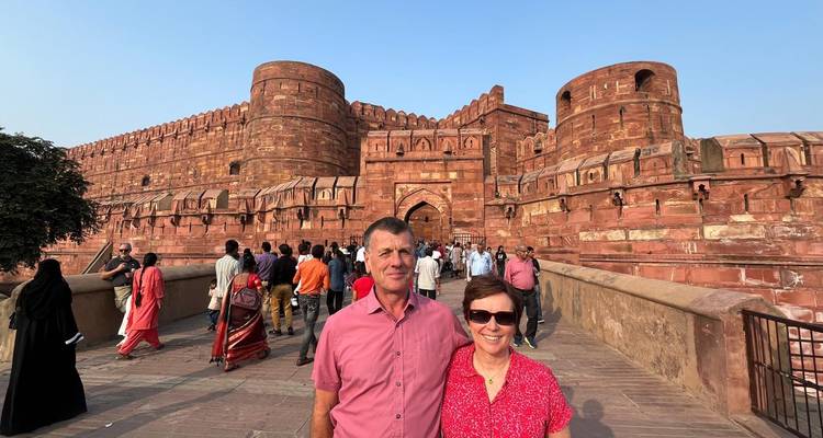 Paar posiert vor einer massiven roten Sandsteinburg.