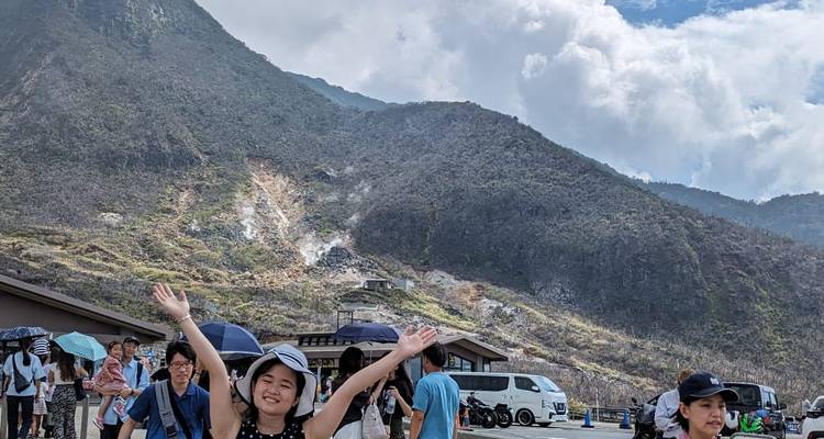Toeristen die genieten van een bergzicht met stoom die uit de grond oprijst.