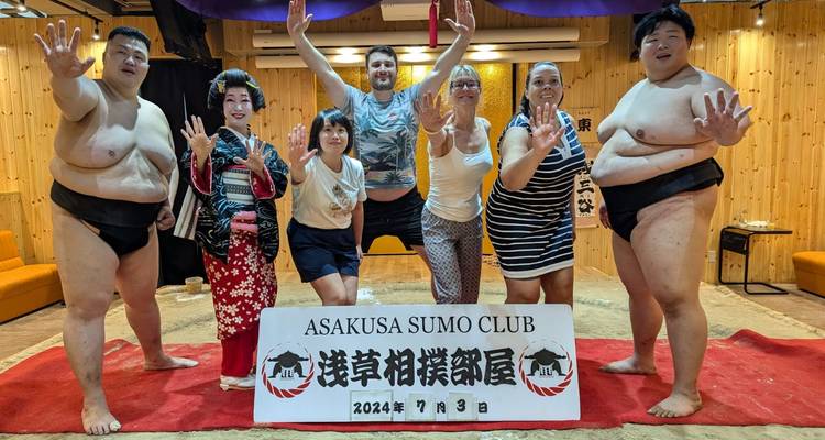 Groep poseert met sumoworstelaar bij een sumoclub.