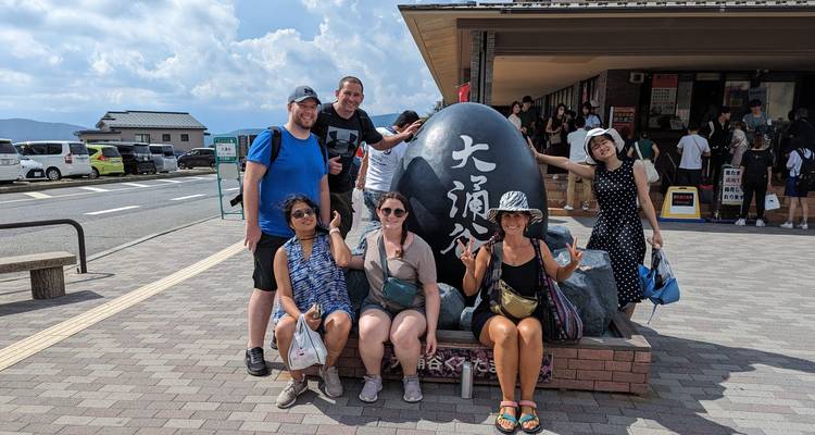 Groepsfoto rond een groot stenen monument.