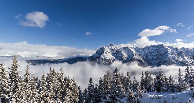 Snow-covered peaks of a mountain range with a clear blue sky.