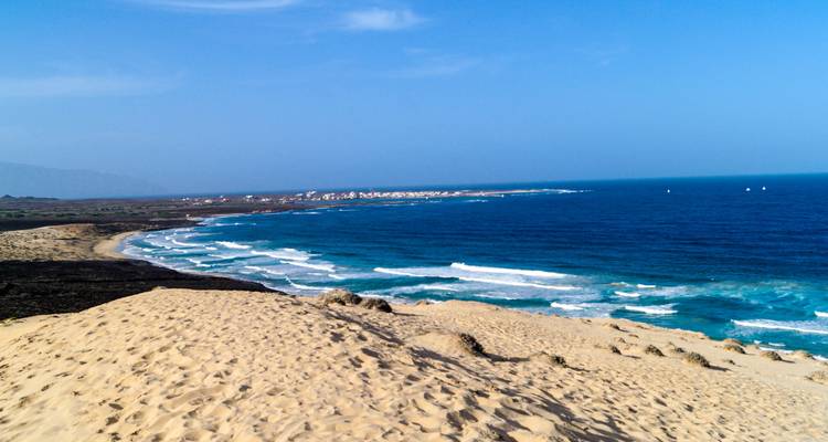 Coastal landscape with sandy dunes overlooking the ocean.