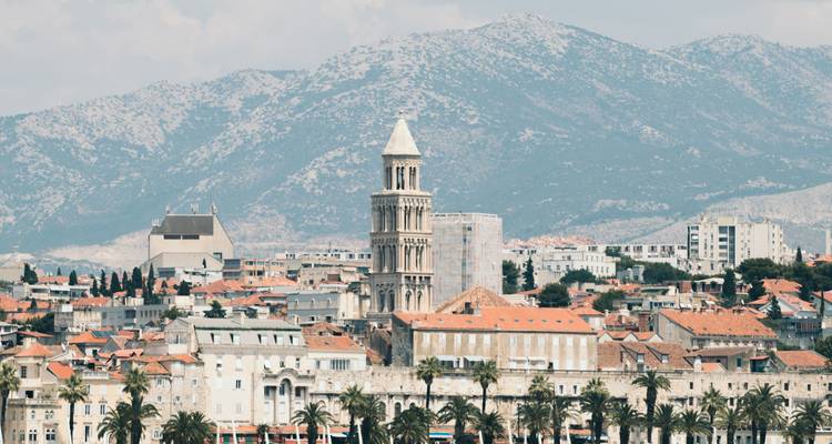 Bell tower of Saint Domnius rising above Split’s old town with rugged mountains behind.