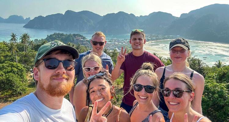 Groupe posant avec une vue panoramique sur la plage en arrière-plan.