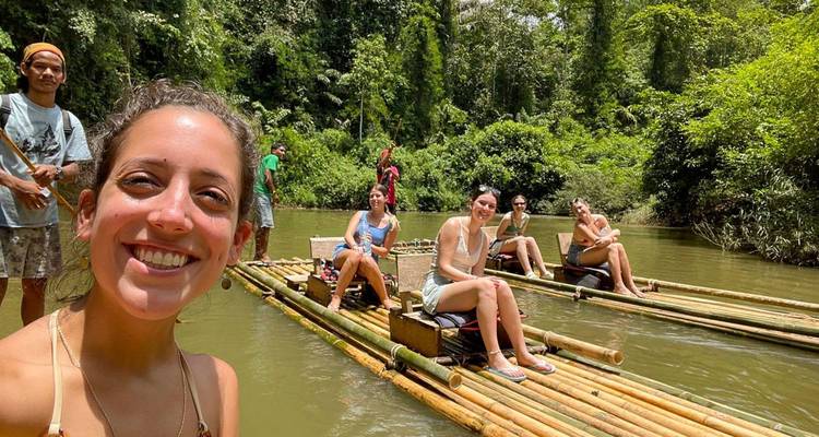 Des gens flottant sur des radeaux de bambou dans une rivière pittoresque.