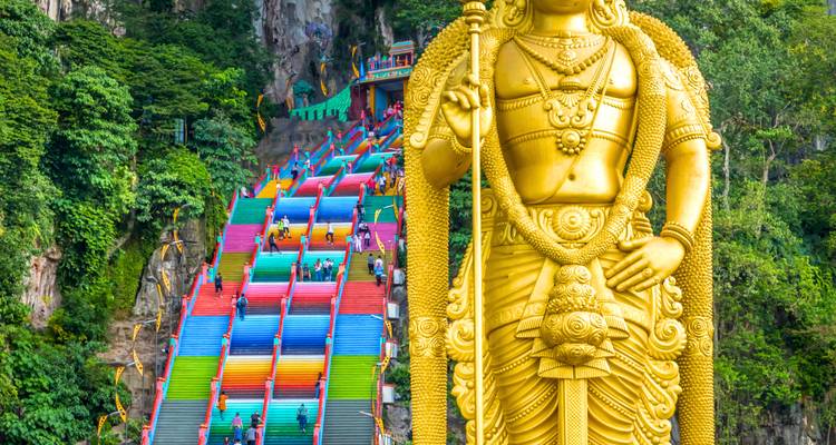 Des marches colorées menant aux grottes de Batu avec une statue géante.