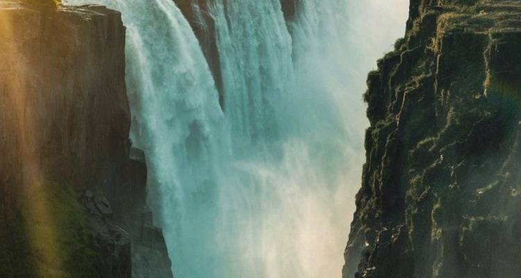 Troupe de cascades vibrantes en cascade avec brume et lumière du soleil.