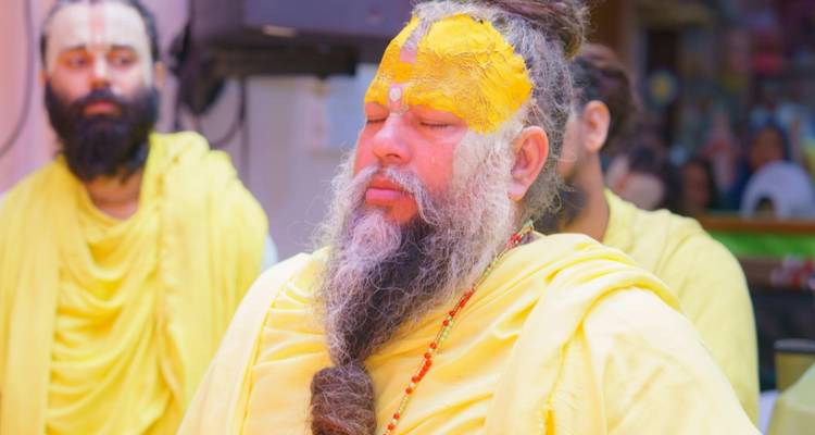 Une personne qui médite avec une poudre jaune sur le visage.