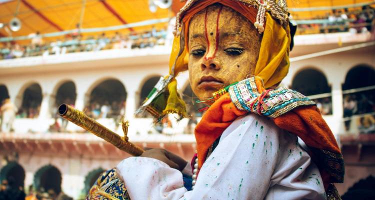 Un enfant vêtu d'un costume traditionnel tenant une flûte.