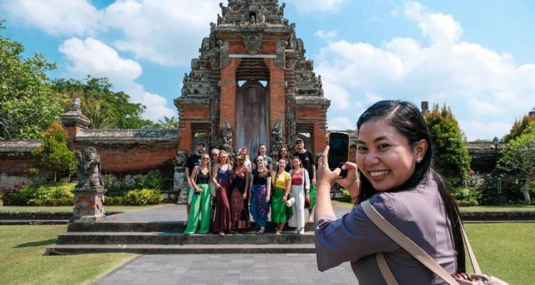 Des personnes en tenue traditionnelle posant devant une porte historique.