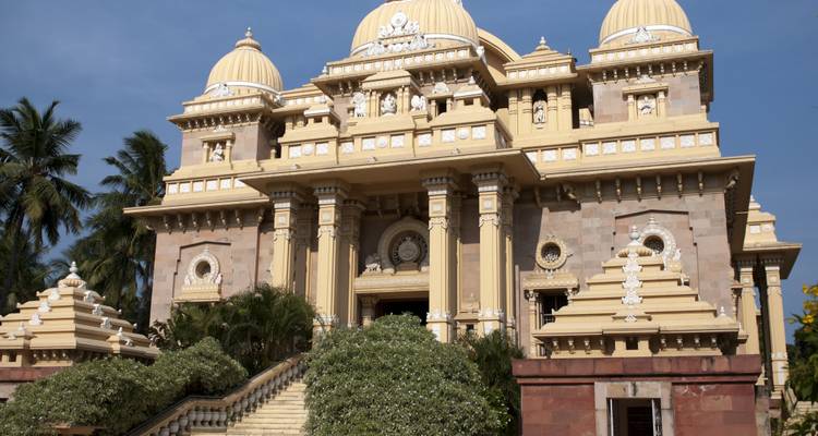 Ornate temple with domes and columns set against a clear sky.