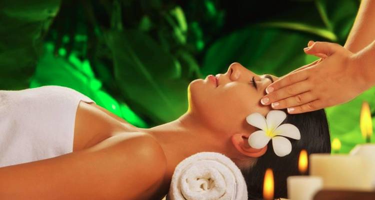 Une femme recevant un massage de la tête dans une atmosphère apaisante.