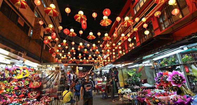 Vibrante calle de mercado nocturno en Kuala Lumpur adornada con hileras de faroles rojos y bullendo de compradores