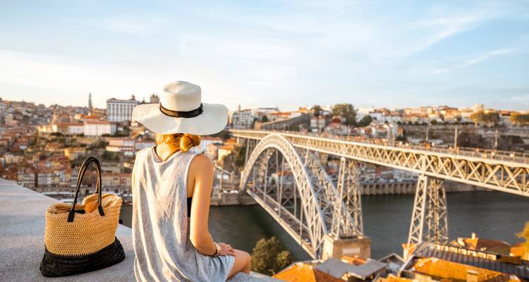 Woman sitting and overlooking the Dom Luís I Bridge.