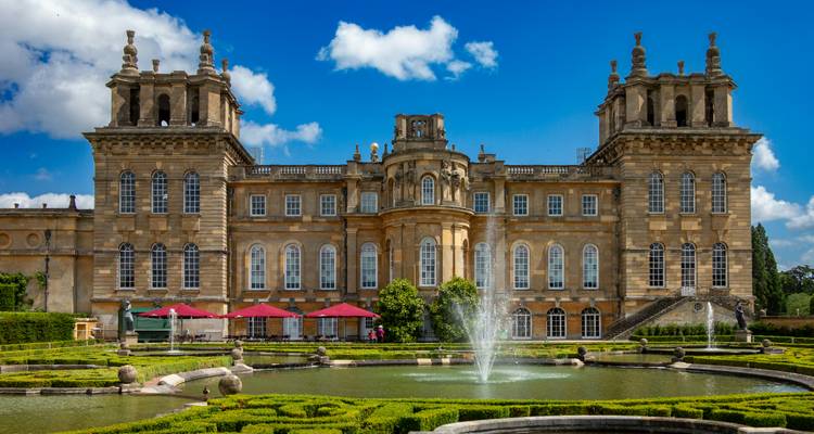 Stately home with beautiful gardens and a central fountain.