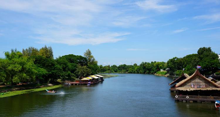 River view with boats and riverside huts.