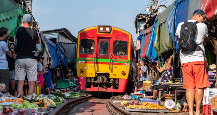 Train passing through a busy market street.